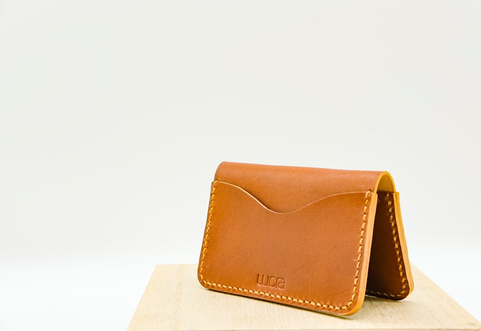 Brown leather wallet displayed on a wooden surface with minimalistic style.