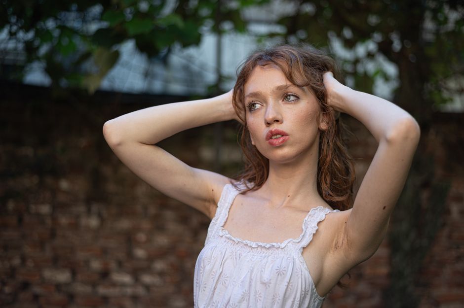 Portrait of a young woman posing outdoors in a relaxed and natural setting, highlighting summer fashion.