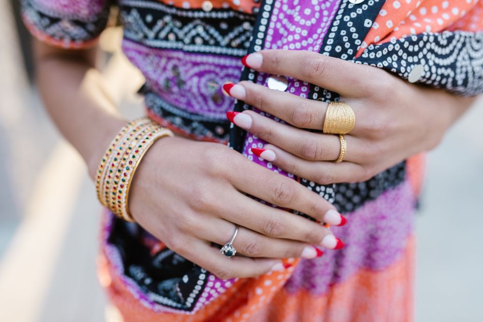 Elegant close-up of hands adorned with vibrant bracelets and rings, showcasing cultural attire.