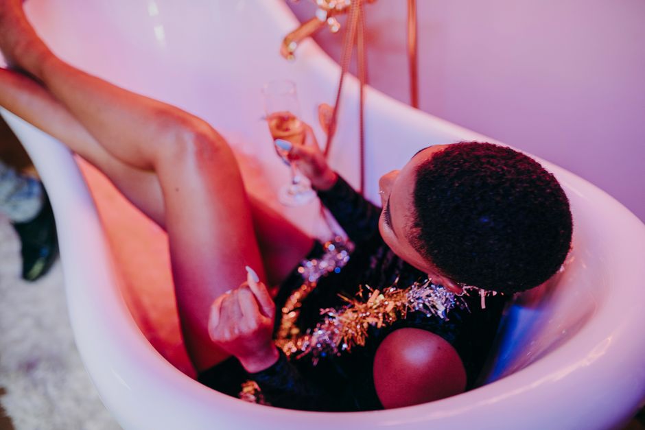 A joyful celebration with champagne and tinsel in a bathtub setting.