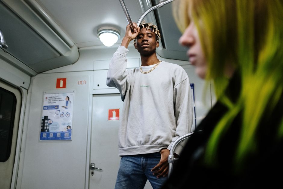 Two people riding the subway showcase urban fashion and diverse styles.