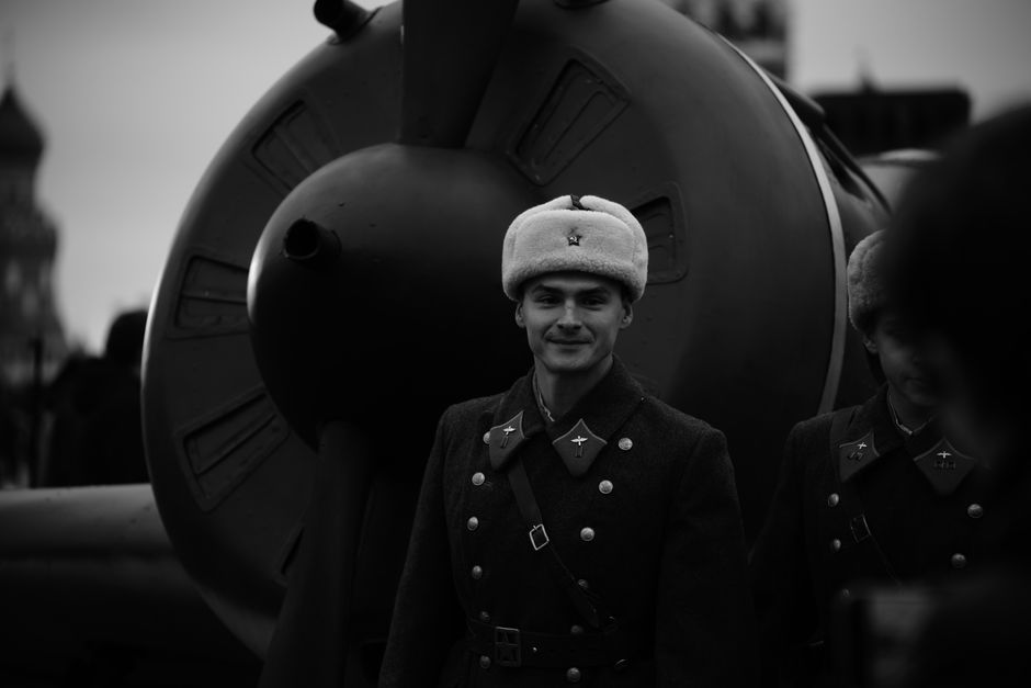 Black and white photo of Soviet soldiers in vintage uniforms beside an old aircraft.