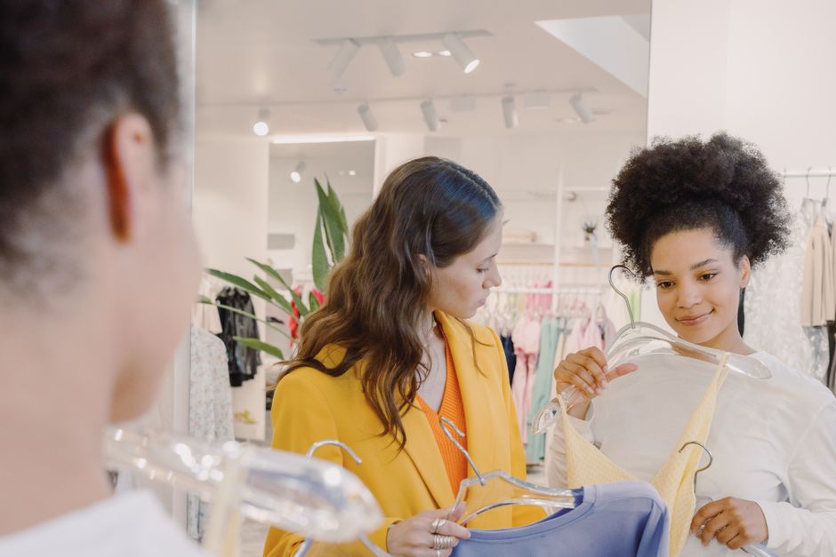 Two women exploring fashion choices in a stylish boutique fitting room.