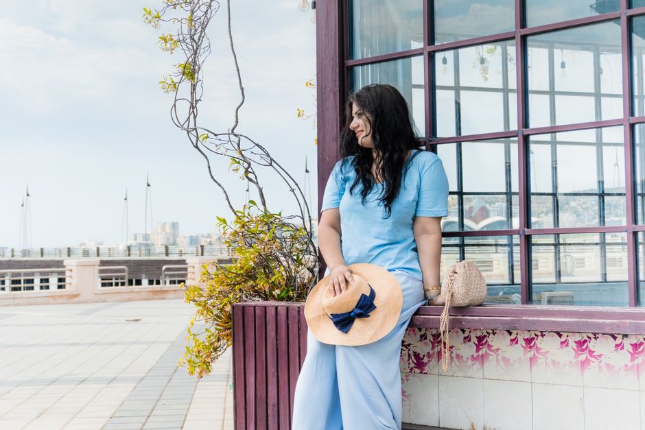 Woman in straw hat enjoying a sunny day in Baku, Azerbaijan, by the waterfront.