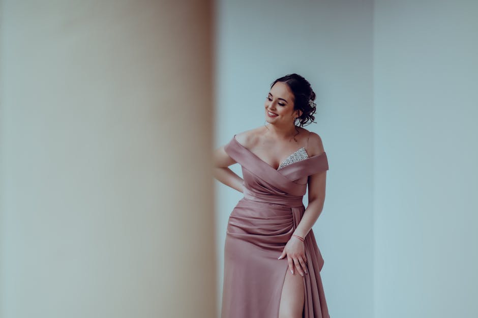 Young woman in an elegant dress posing indoors, exuding confidence and style.